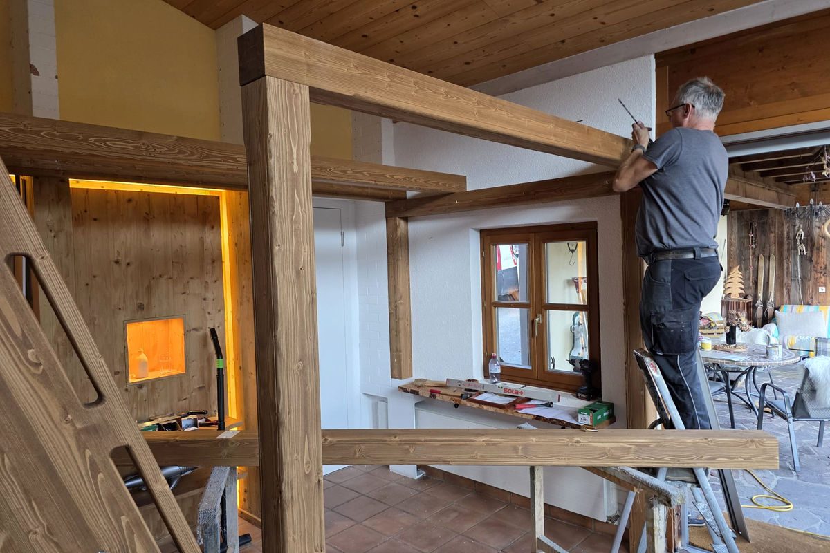 Handwerker montiert Holzbalkenkonstruktion